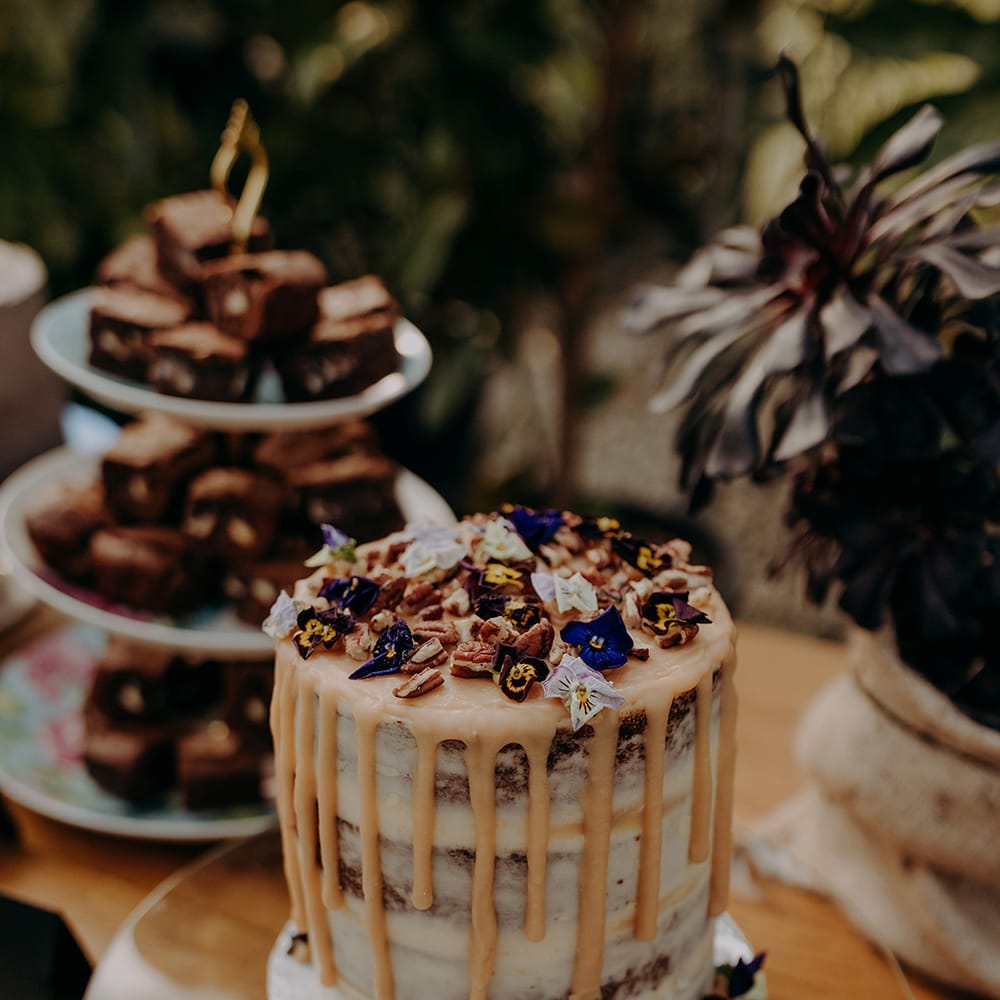 Naked cake with dry icing, flowers and walnuts