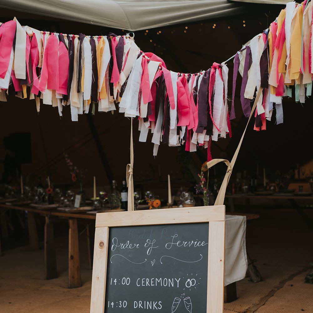 DIY chalkboard order of the day signage below colourful bunting 