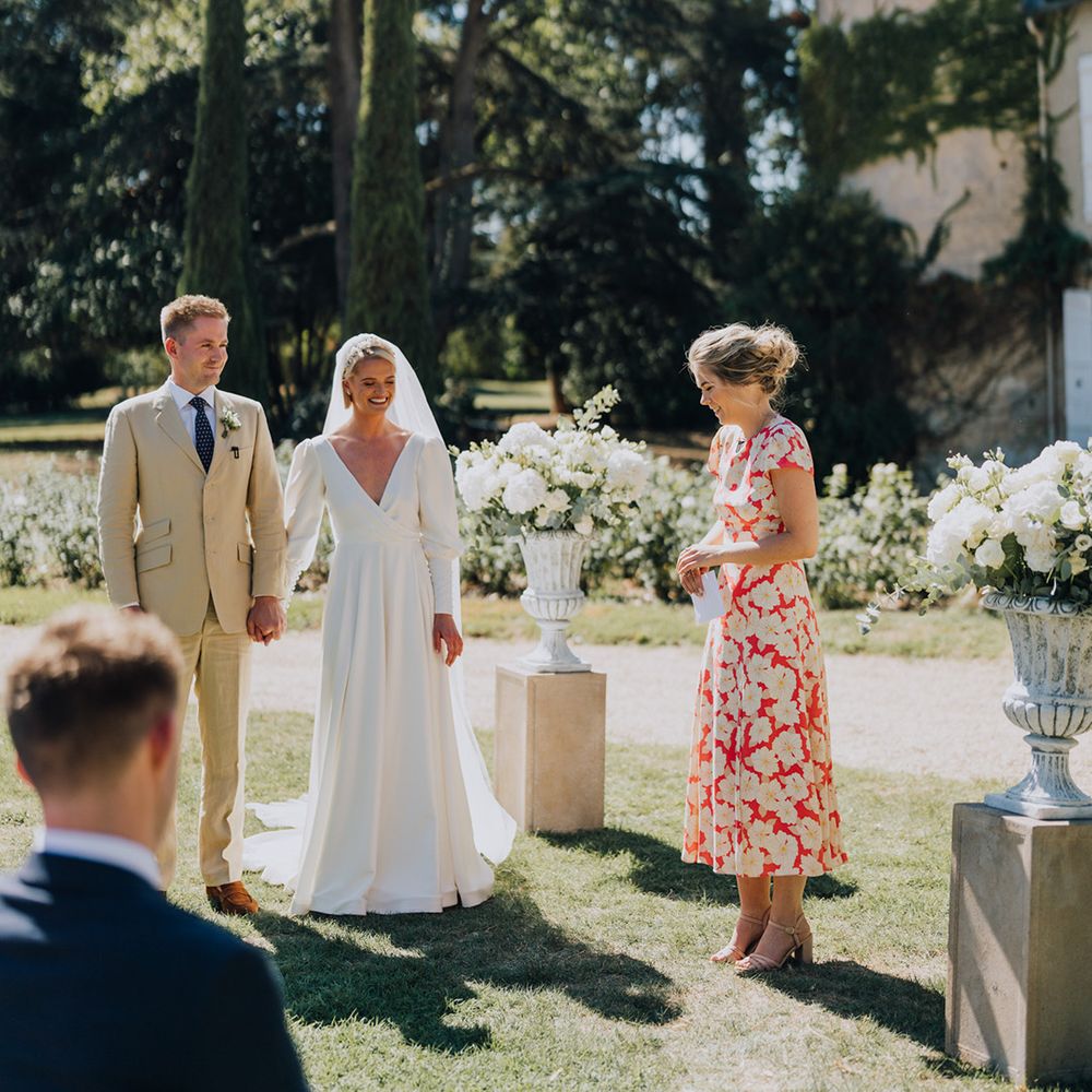 Outdoor wedding ceremony at Château de Malliac with bride in a bespoke Emma Beaumont wedding dress and groom in a beige suit