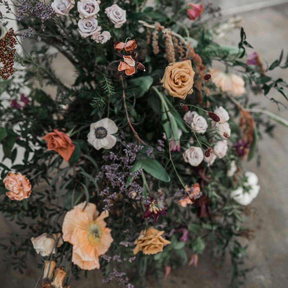 Dried wildflower wedding flower arrangements with roses, poppies and carnations at Buxted Park