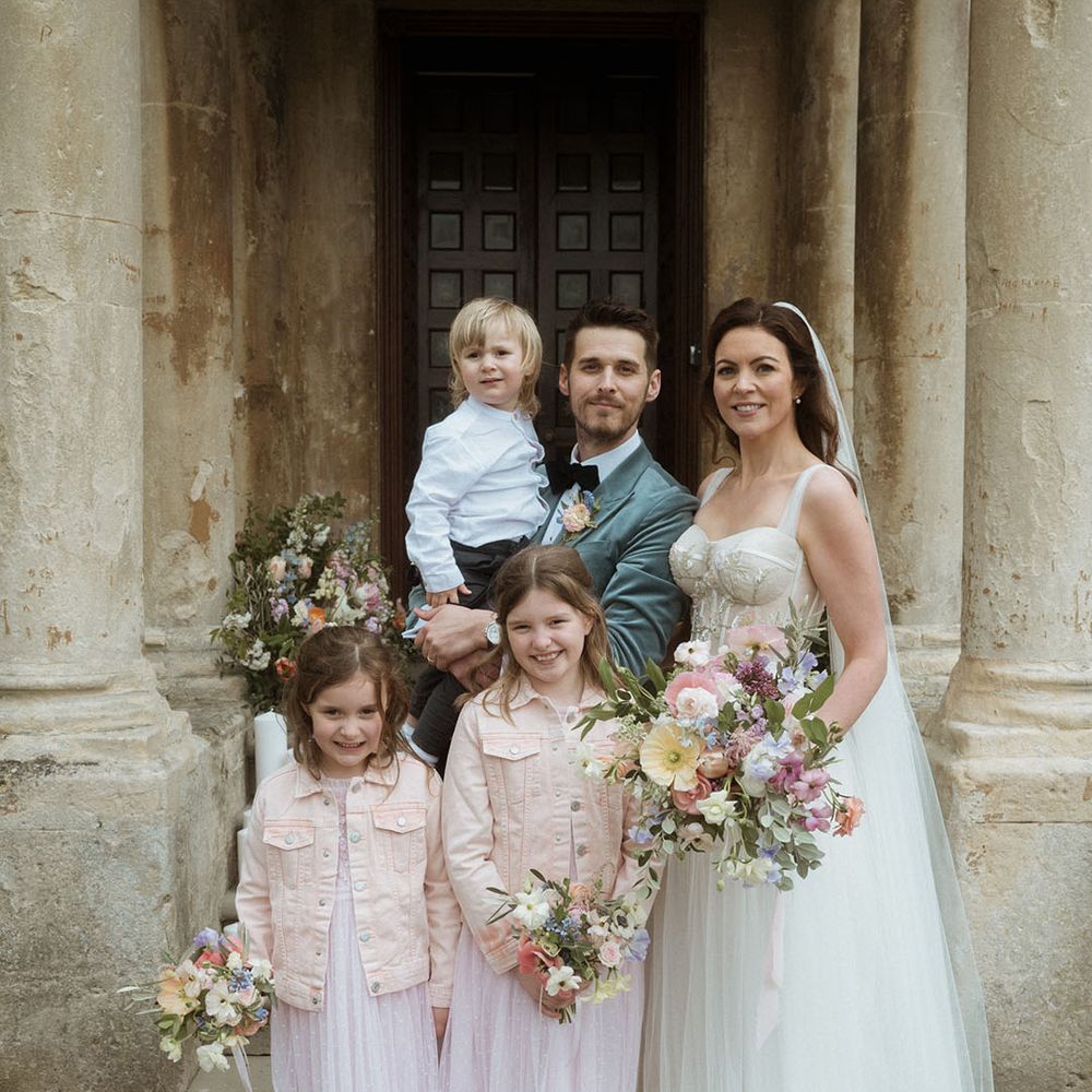 Family wedding photo of the bride and groom with their three children 