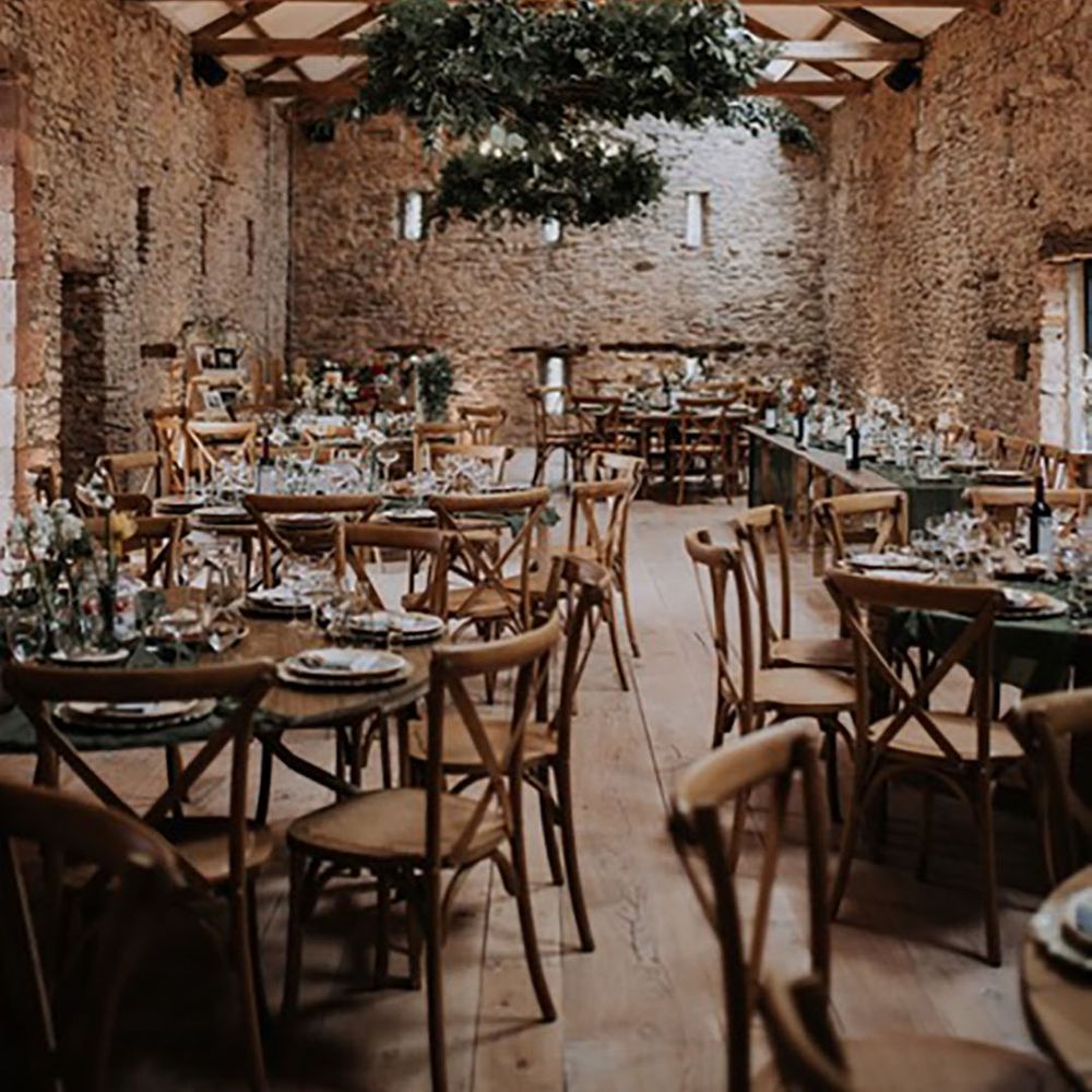 Rustic Holesfoot wedding venue with foliage decorating the chandelier with simple wedding table decor 