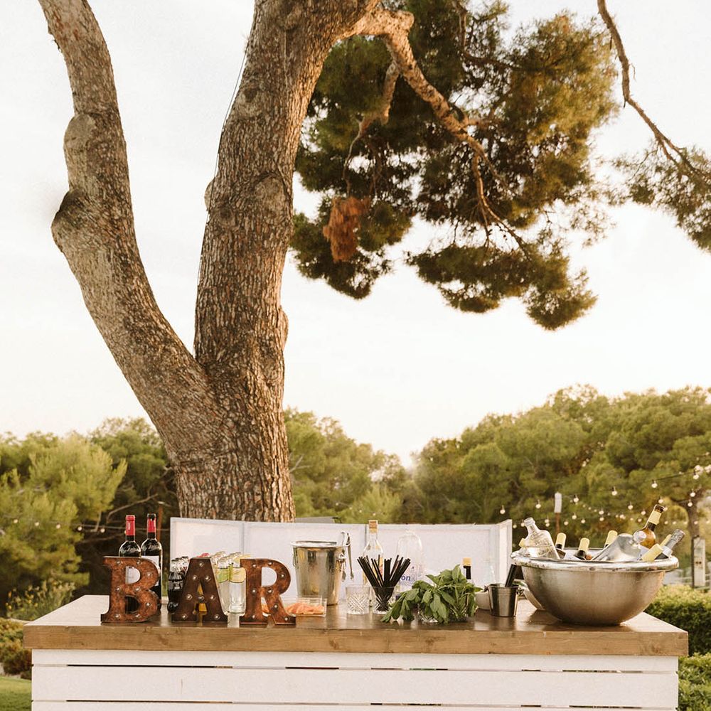 Destination wedding with whit wooden bar with rustic 'bar' sign 