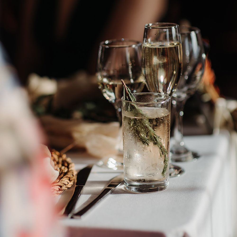 Glasses of wine and beverages for the wedding guests with garnishes 