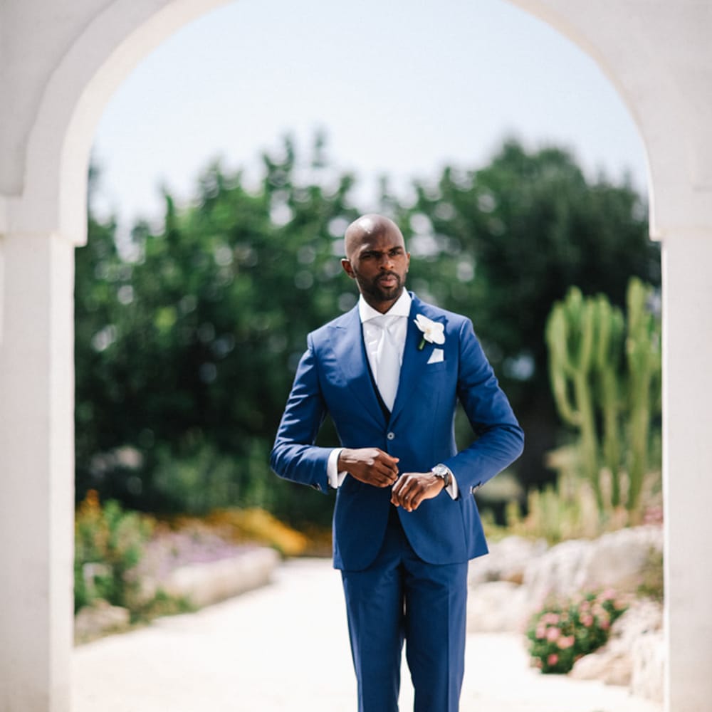 Groom wearing three piece blue suit 