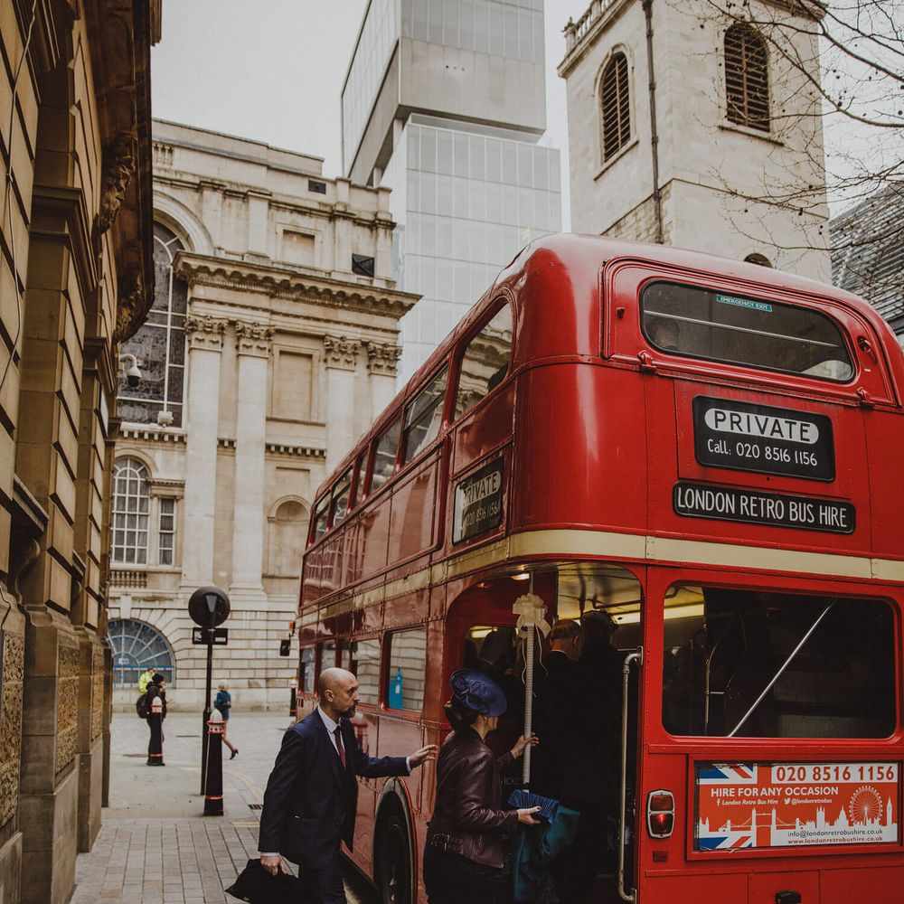 Wedding guests stepping into Retro London bus for wedding in the city