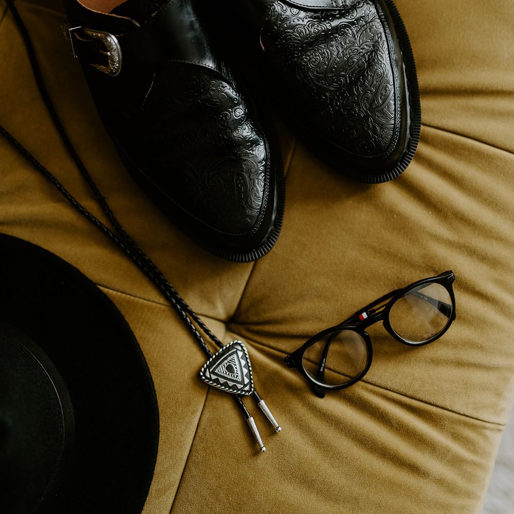 Dr Martens shoes next to glasses for grooms wedding day attire