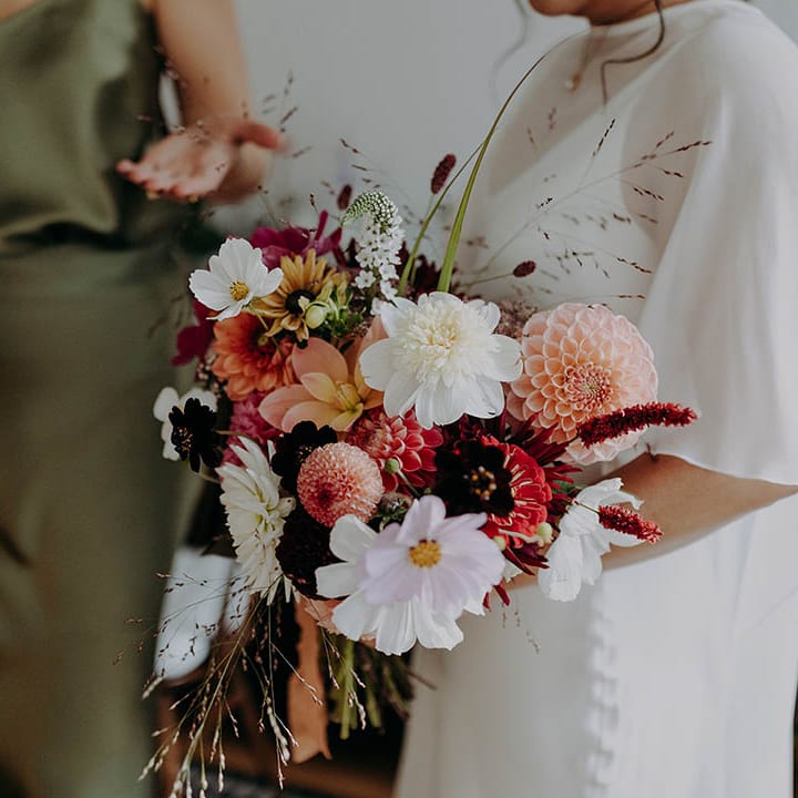 Bride holds brightly coloured floral bouquet on the morning of her wedding day | Irene Yap Photography