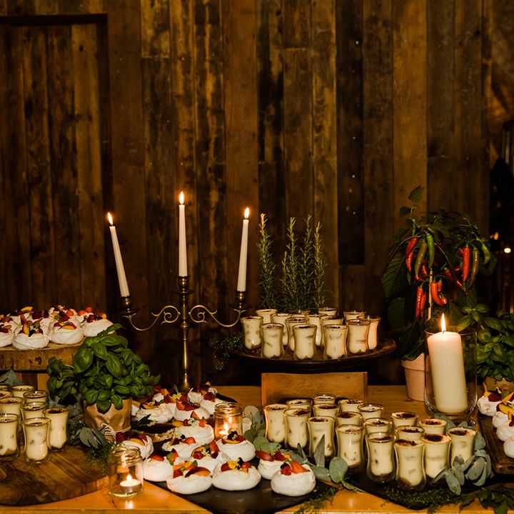 Selection of desserts for wedding guests with gold candelabras and chilli plants
