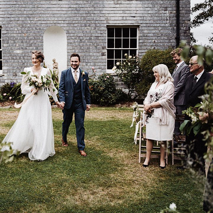 Bride and groom walk back down the aisle as a married couple