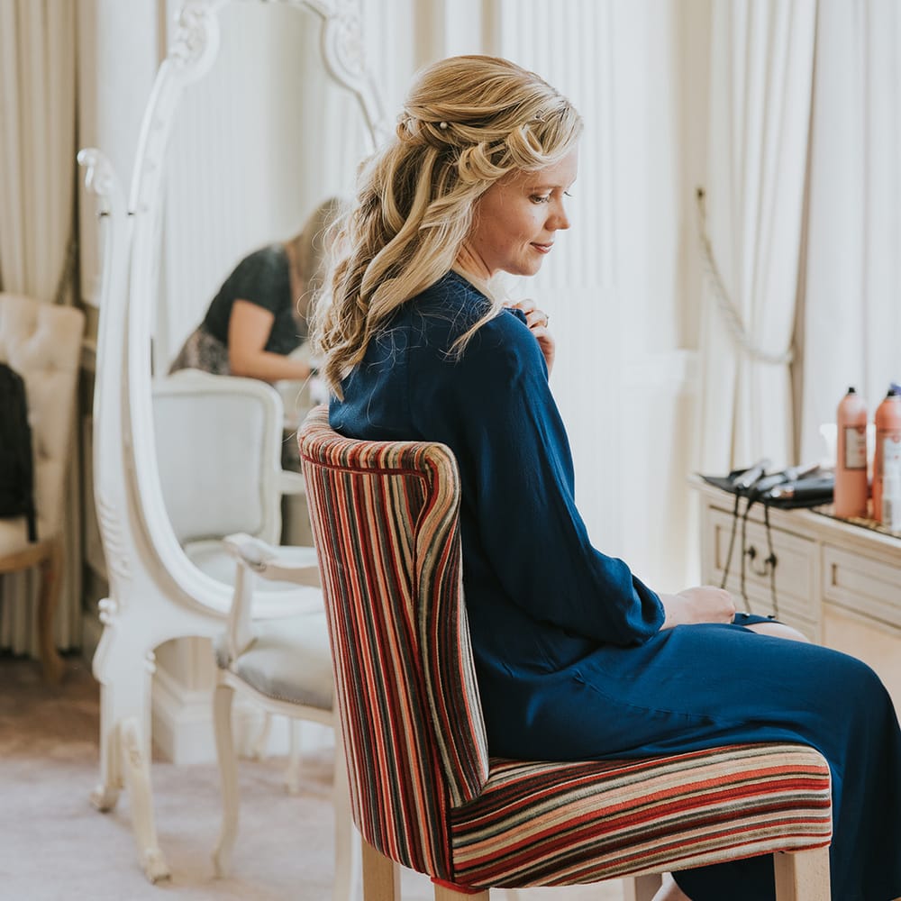 Bride with half up half down wedding hair with pearl hair pins in blue satin pyjamas 