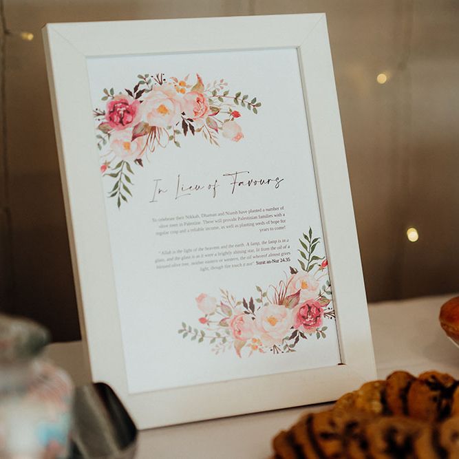 Doughnut stand beside white stationery sign finished with watercolour styled florals