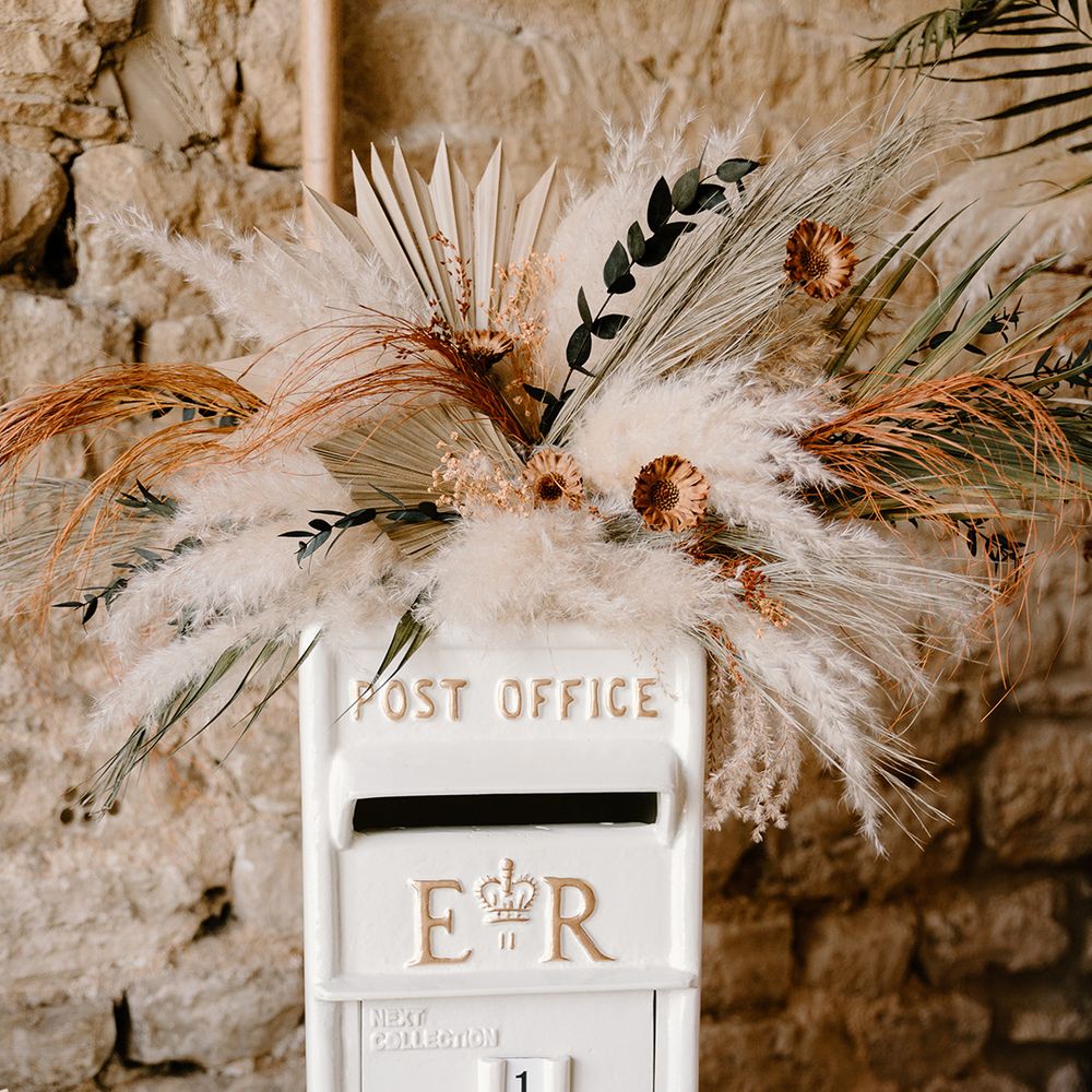 White post box painted and decorated with pampas grass for the wedding cards from guests 