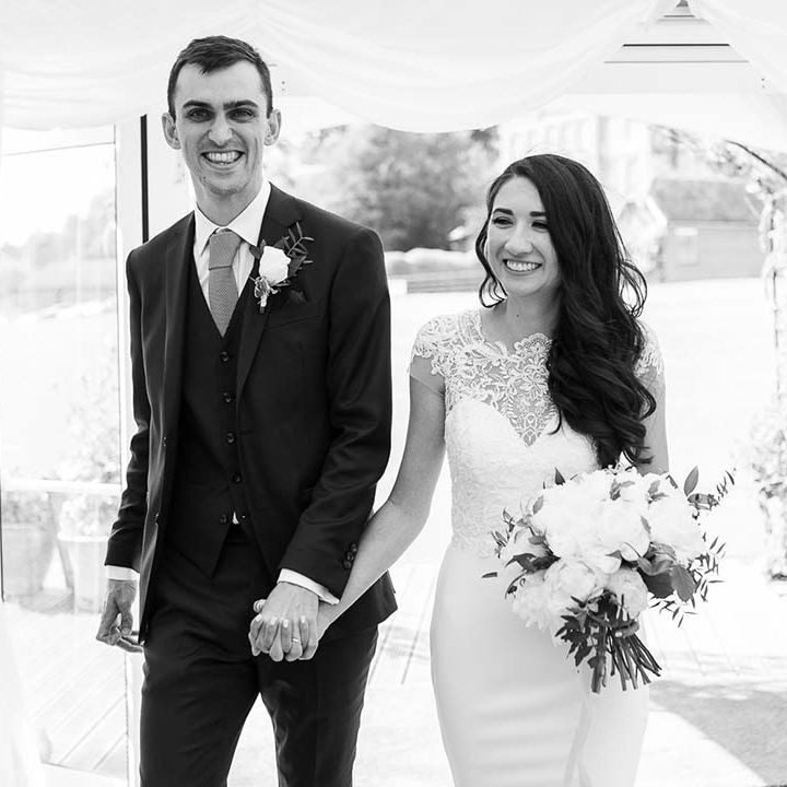 bride and groom entering the marquee wedding reception holding hands 