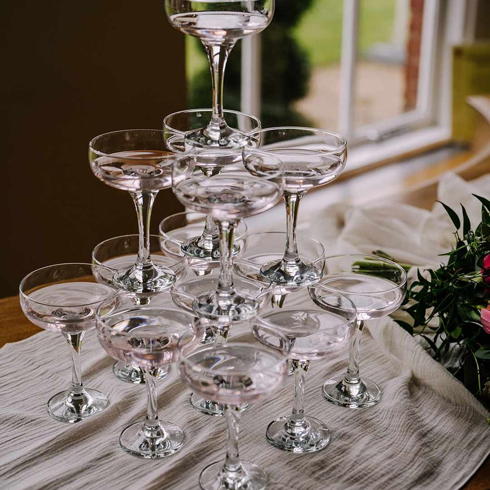 Classic wedding champagne tower on white wedding tablecloth 