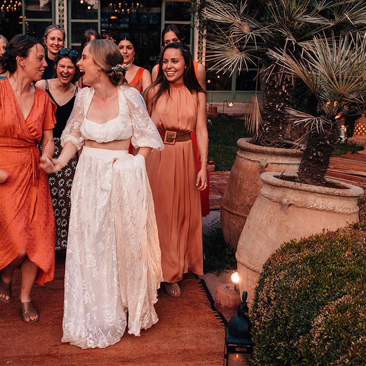 Wedding guests in orange and red wedding outfits for destination wedding in Marrakech 