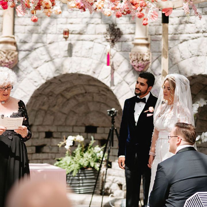 Woman in black sparkly dress performs the wedding ceremony for the bride and groom at De Vere Tortworth Court Wedding 
