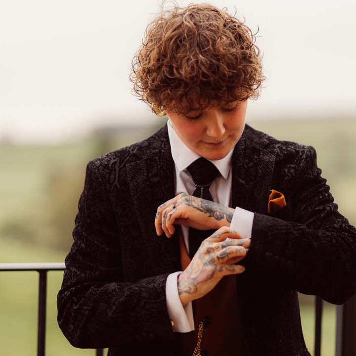 Bride in dark velvet bridal jacket with rust waistcoat and pocket square 