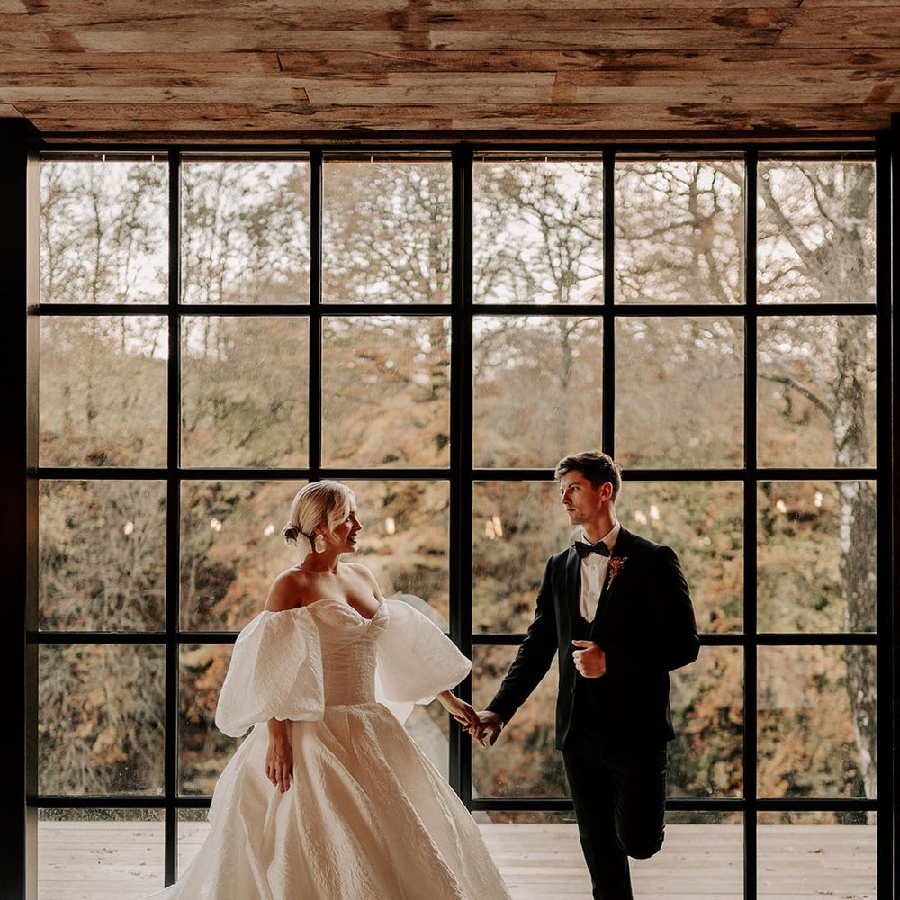 Hidden River Cabins barn wedding venue with bride in princess wedding dress with statement puff sleeves and groom in tuxedo 