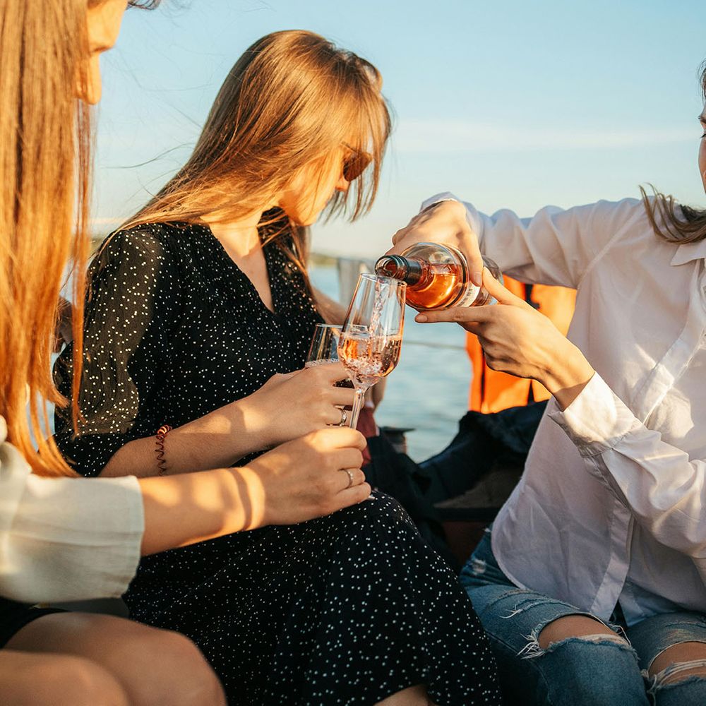 Stock image of man pouring a drink for a woman on a boat 