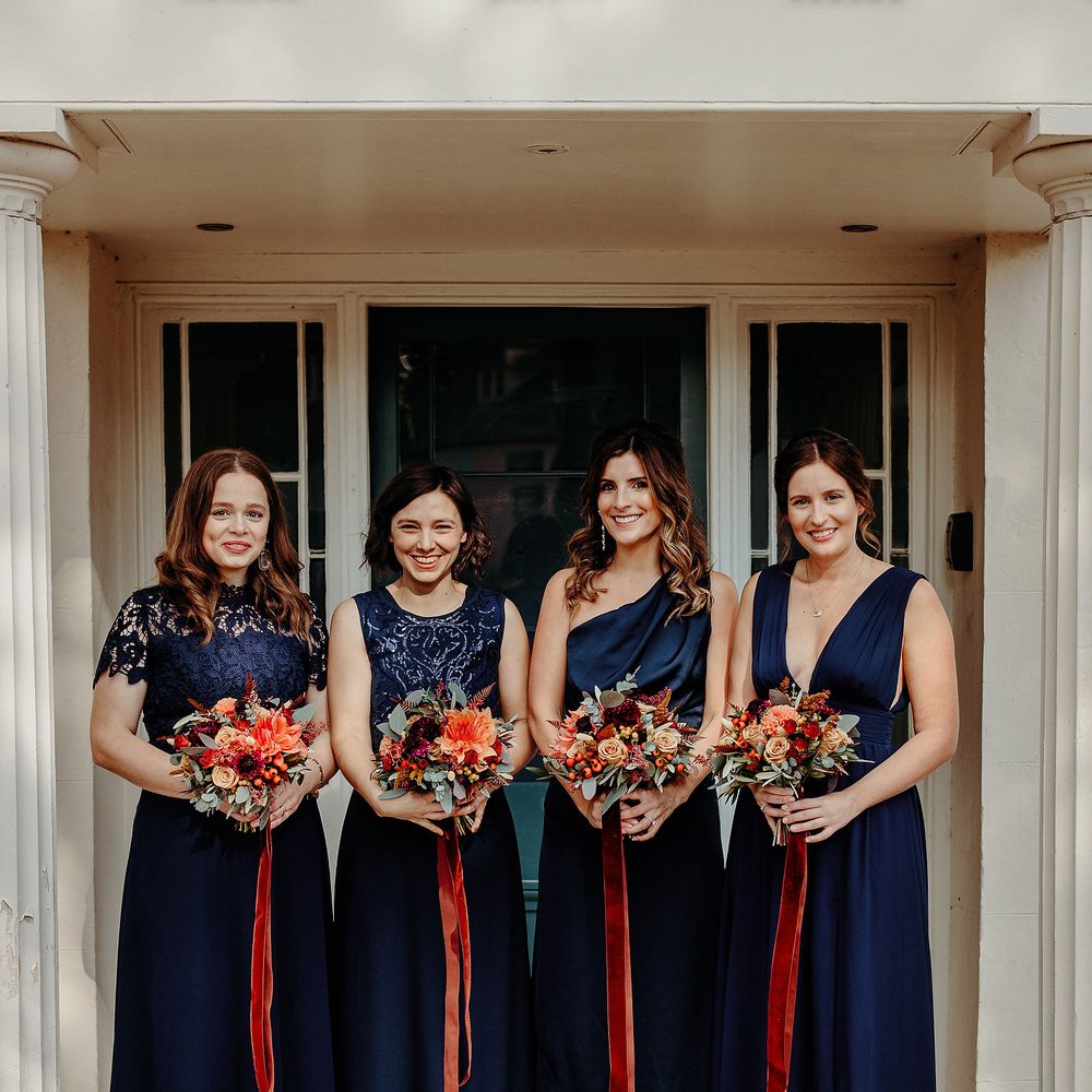 Deep blue bridesmaids dresses with contrasting Autumnal bouquet