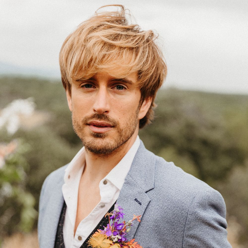 Groom wears pastel blue suit complete with floral buttonhole 