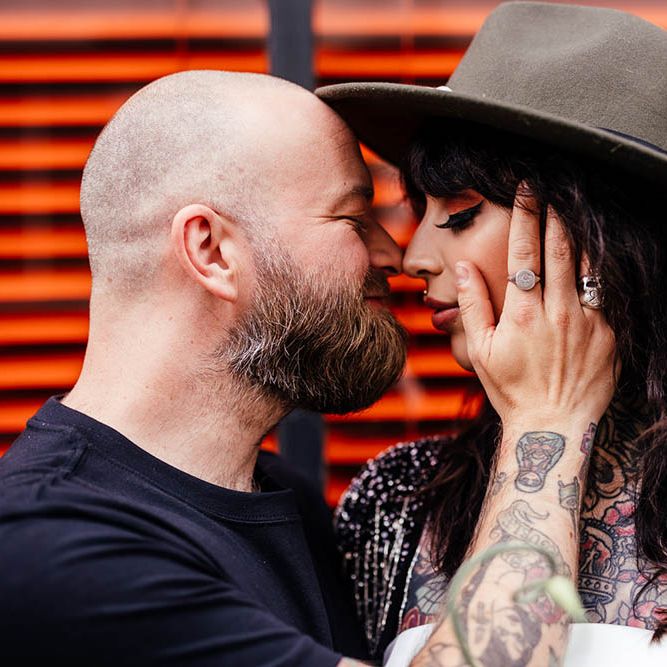 Groom in a black t-shirt embracing his brides cheek 