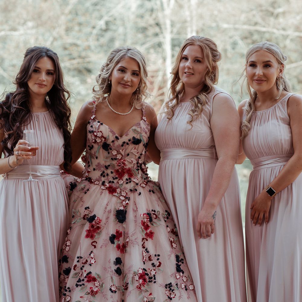 Bride stands with bridesmaids on her wedding day 