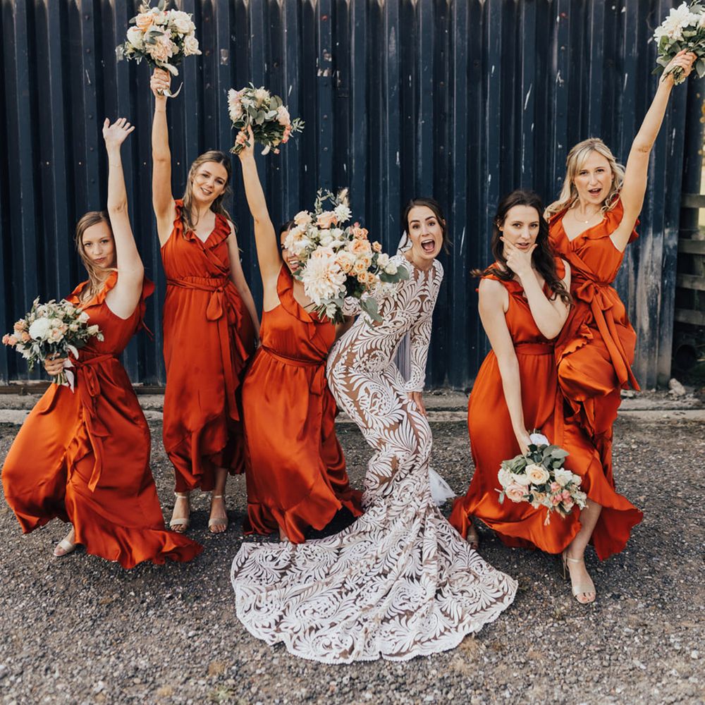 Bride in Rue De Seine (wedding dress) with bride party in orange bridesmaid dresses at Elmley Nature Reserve