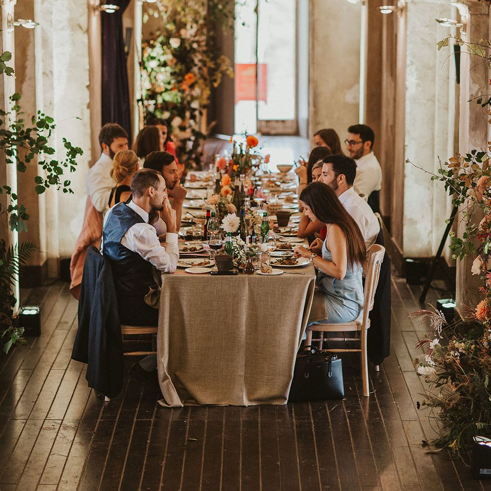 Wedding guests sit down during reception dinner in rustic setting