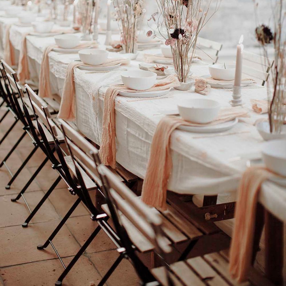 Modern gothic wedding table decor with long elegant flower stems ascending from rustic cream glazed finger bowls
