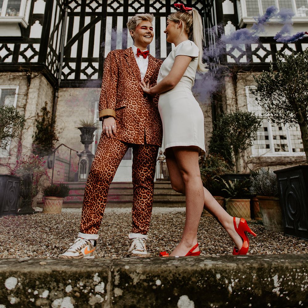 Two brides at retro wedding at The high field House with leopard print suit, short wedding dress and bow accessories 