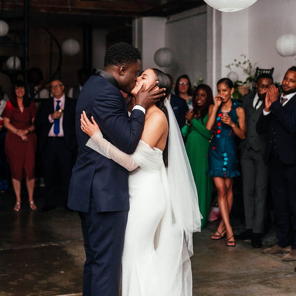 Bride in off shoulder lace sleeved wedding dress and groom doing first dance 