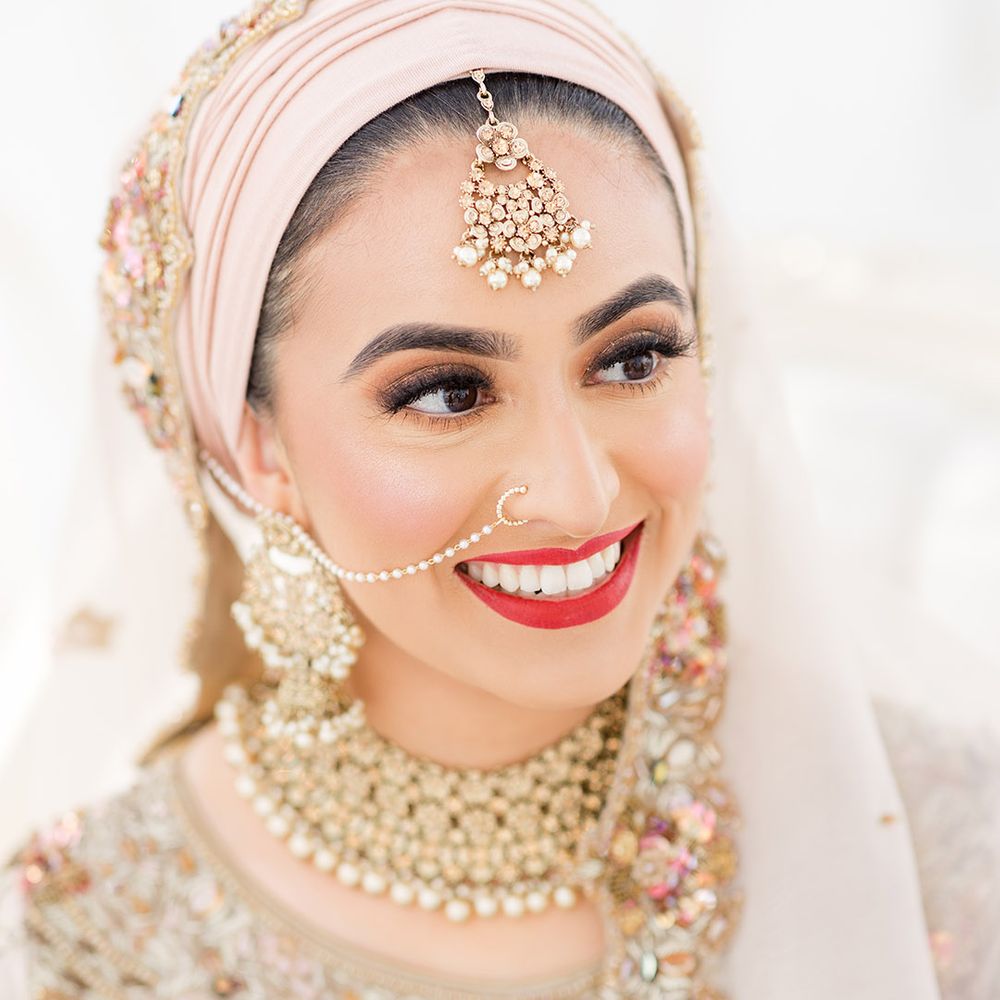 Bride wears red lipstick and traditional gold jewellery for Walima at the Isla Gladstone Conservatory