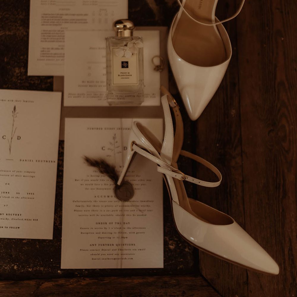 White patent slingback wedding shoes with wedding stationery and Jo Malone perfume 