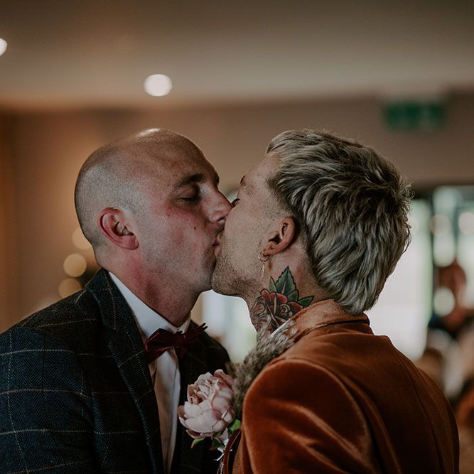 Grooms kiss on their wedding day during boho chic ceremony 
