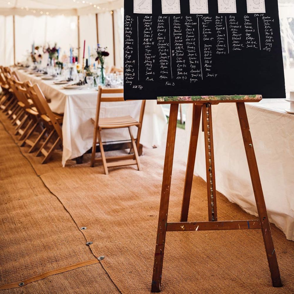 DIY chalkboard seating plan on an easel at marquee wedding