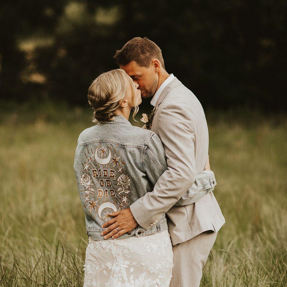 Bride in a light denim jacket reading 'Ride or Die' with a cool pattern for rustic wedding 