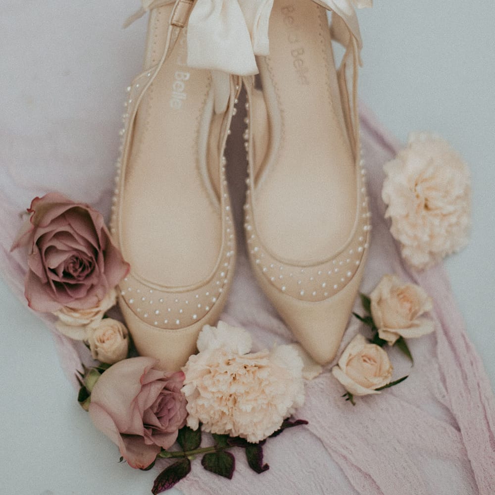 Cream Bella Belle high heels with pearls, surrounded by neutral, pink and white roses