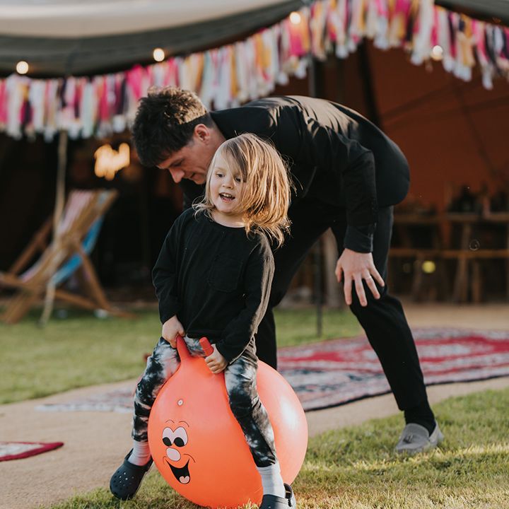 Children and wedding guests play garden games outdoors 