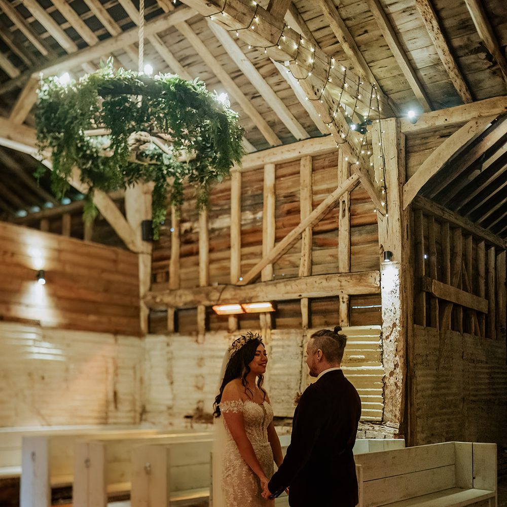 The bride and groom stand facing each other and gaze into each other's eyes for their first look moment 