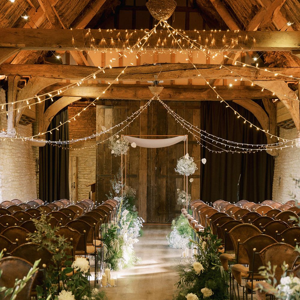 The Tythe Barn Launton barn wedding venue decorated with white wedding flowers with wedding fairy lights 