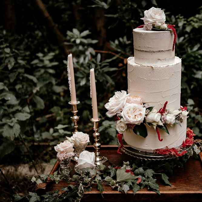 Buttercream wedding cake on vintage dresser with candlesticks