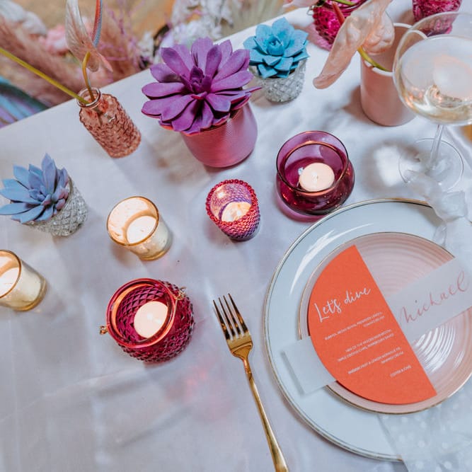 Place setting with colourful stationery and votives 