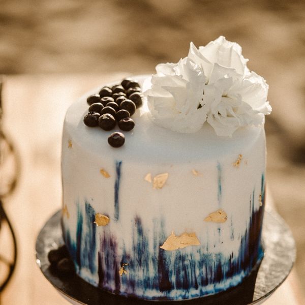 Single tier wedding cake with blue base for beach wedding