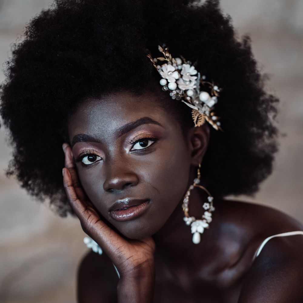 Black bride with afro hair, shimmering eyeshadow and lip gloss bridal makeup 