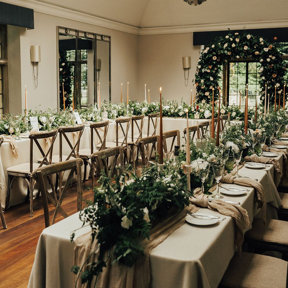 Intimate Foxhill Manor wedding with flower arch, foliage table runners and taper candles 