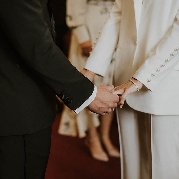 Bride and groom hold hands during their wedding ceremony 