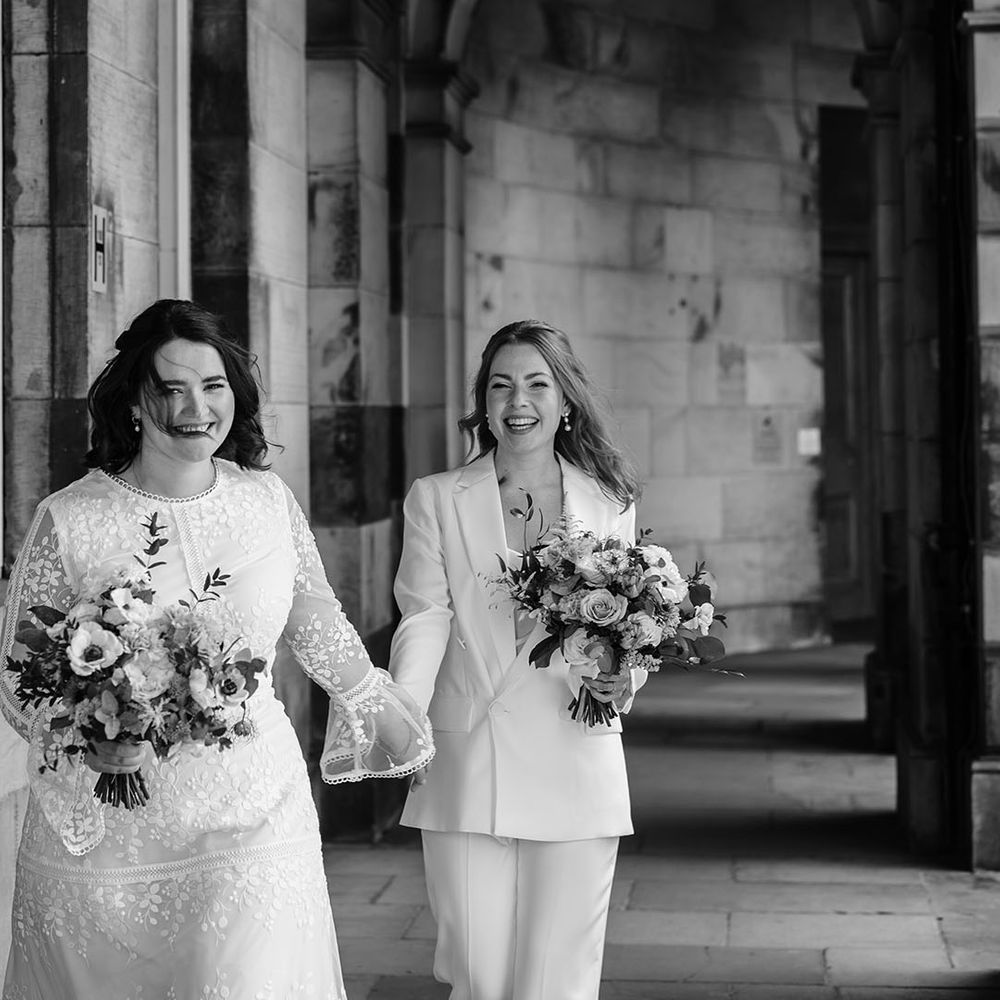 Brides hold hands in black and white image 