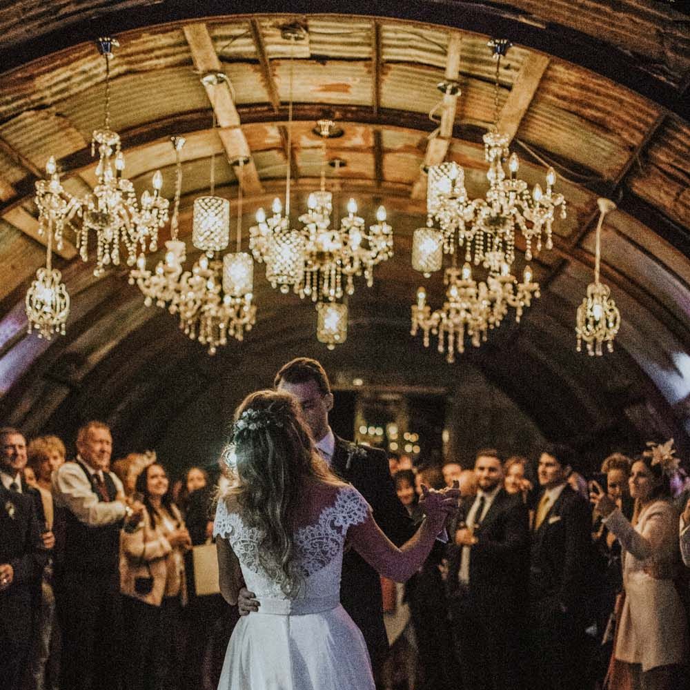 Bride and groom first dance at Anna in Devon with handing chandeliers on the dance floor 
